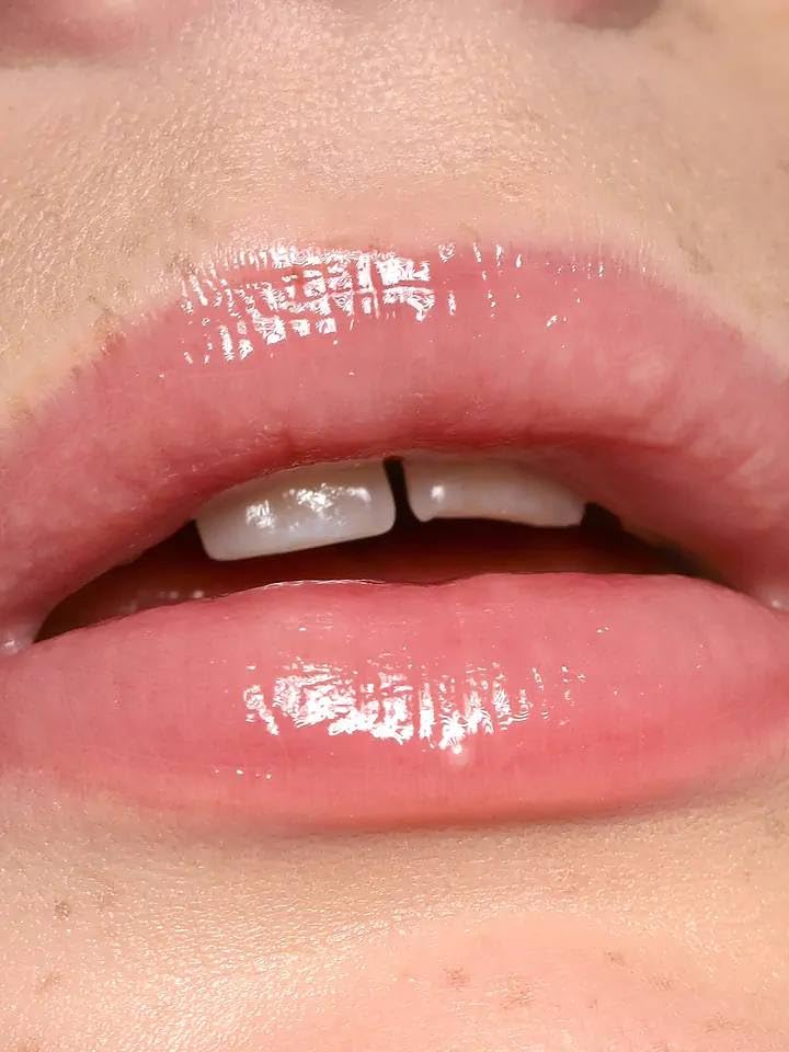 REFY Blush Lip Gloss swatch on lips showing light pink shade and shine.