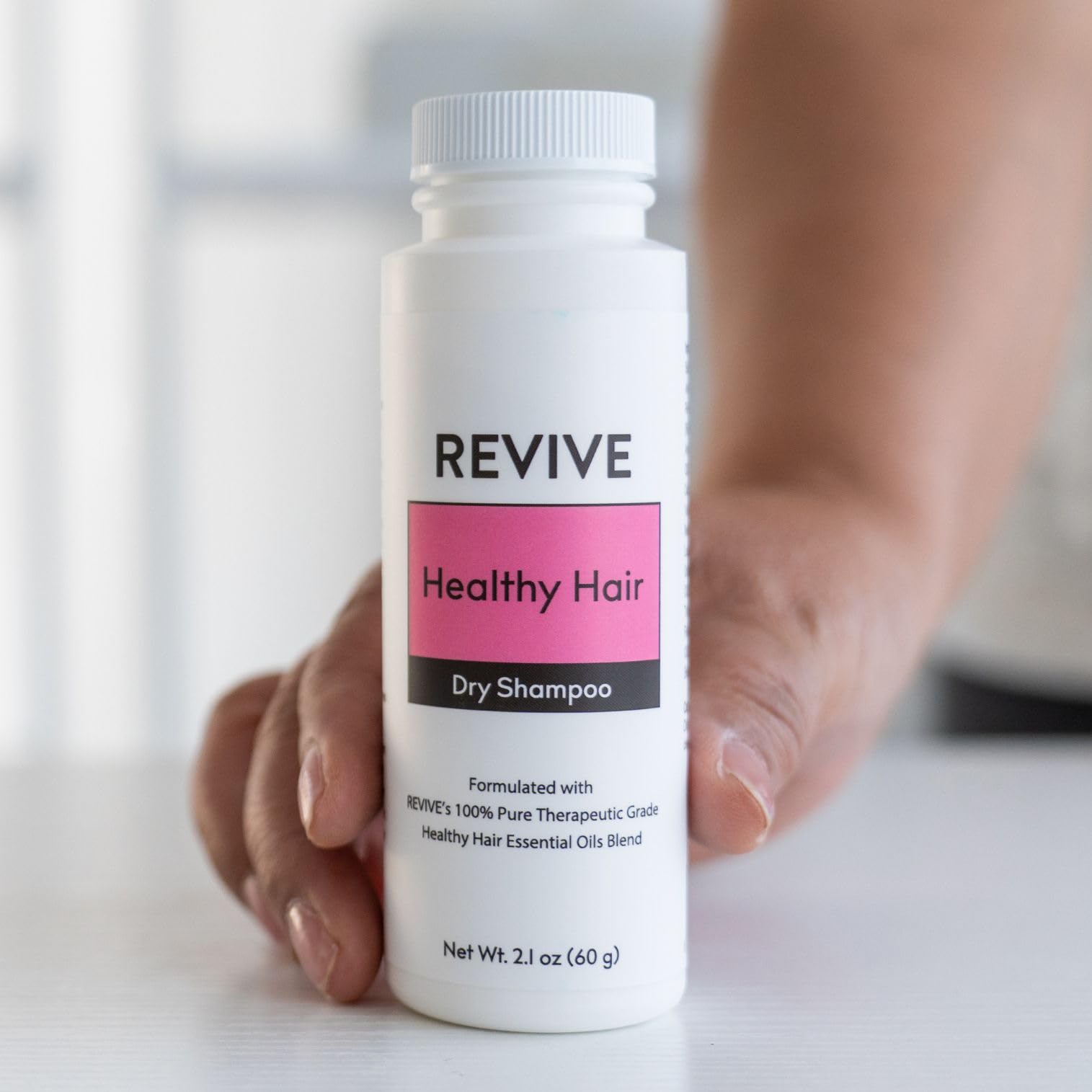 REVIVEEO dry shampoo powder applied to hair for instant refresh without water.