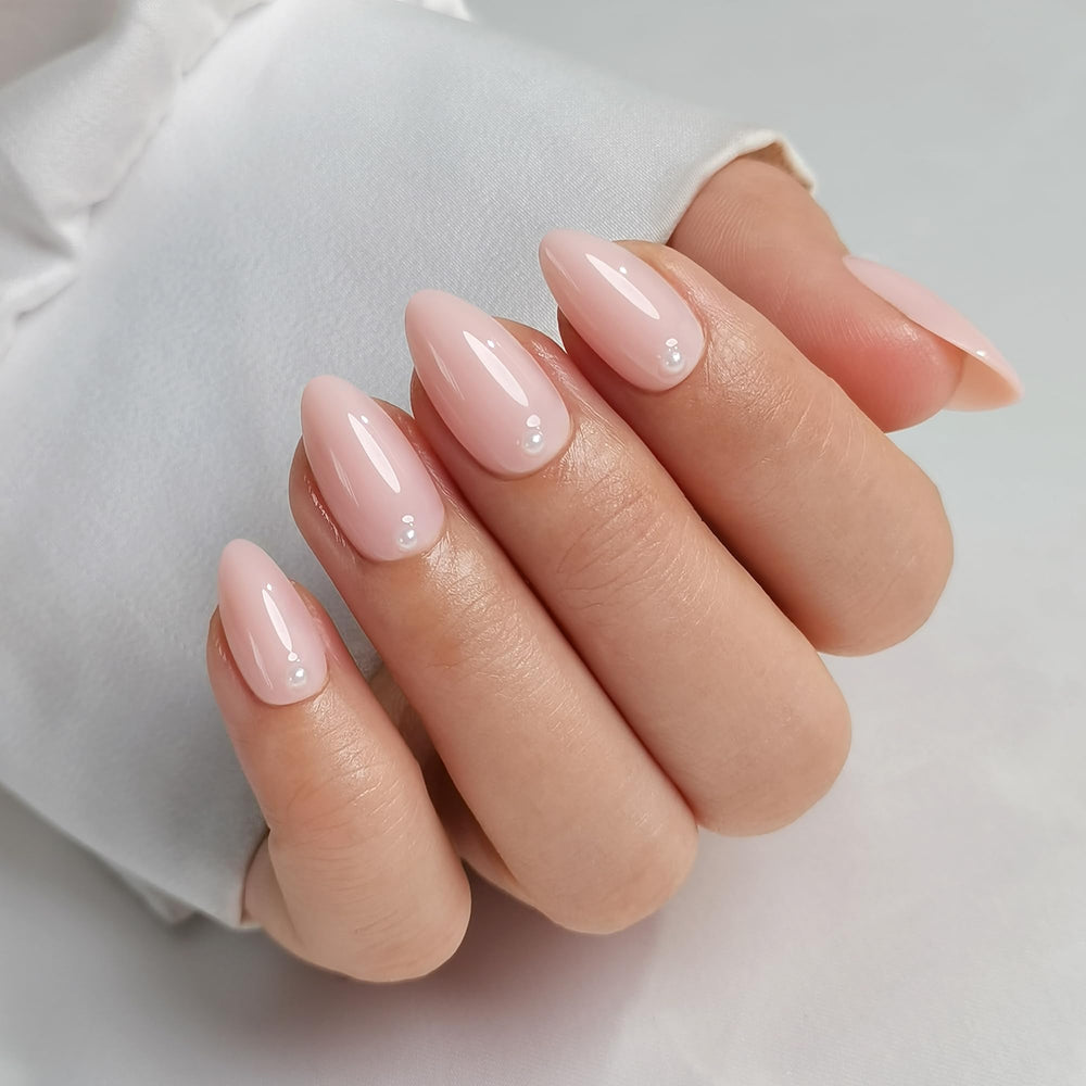 Medium almond RPNZL nails with pearl accents for elegant manicure at home.