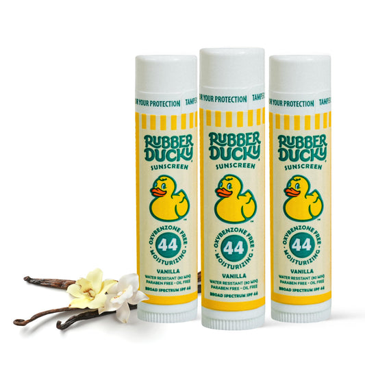 Rubber Ducky SPF 44 lip balm at the beach protects and hydrates lips.