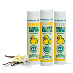 Rubber Ducky SPF 44 lip balm at the beach protects and hydrates lips.