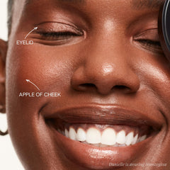 Saie Glow Sculpt large brush applying on the cheekbones for lift and glow.
