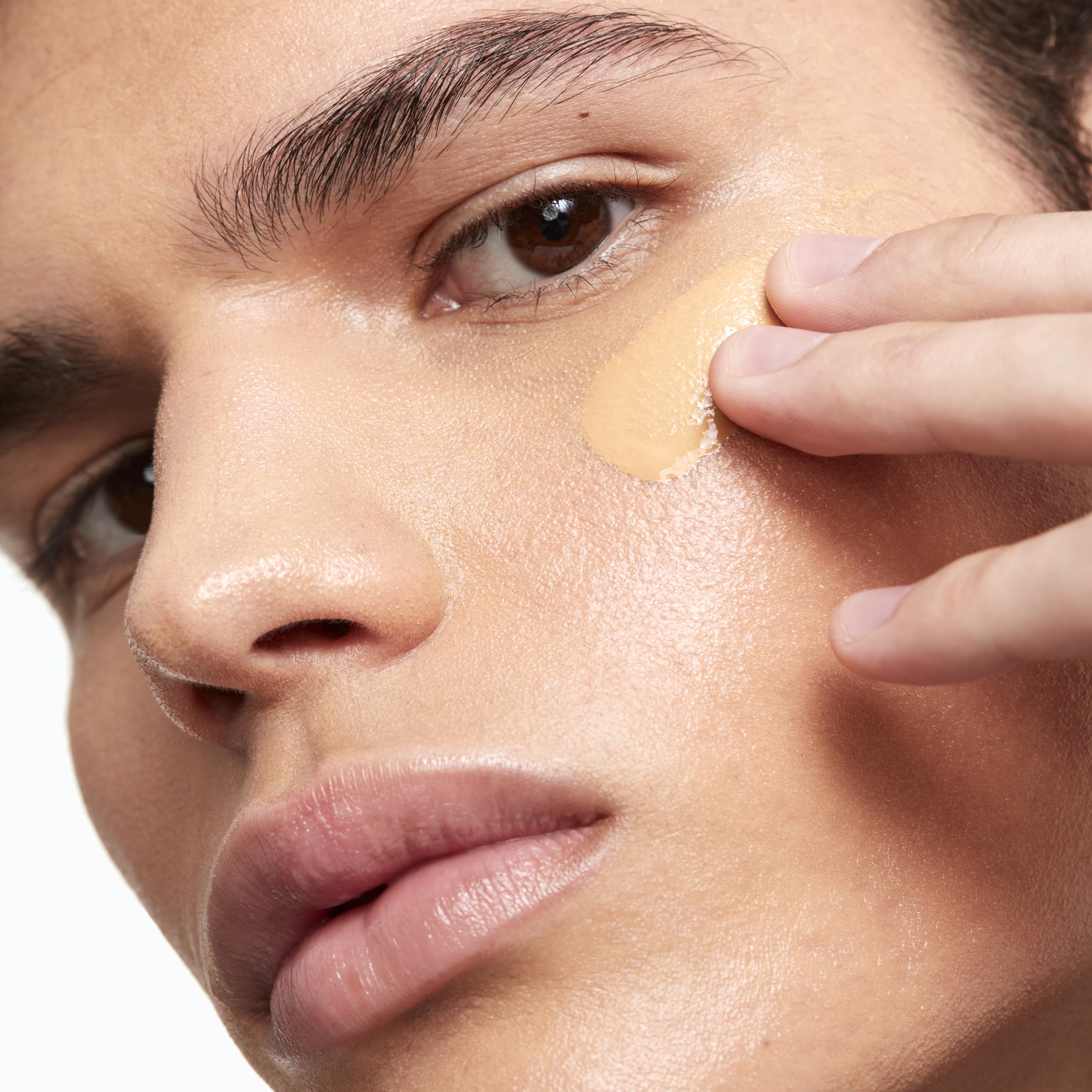Application brush blending Saie Glowy Super Skin Tint for smooth coverage
