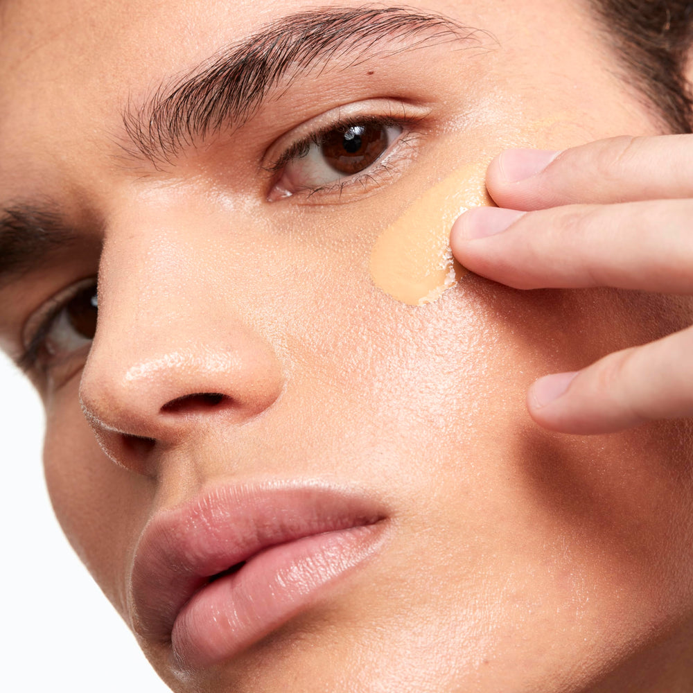 Application brush blending Saie Glowy Super Skin Tint for smooth coverage