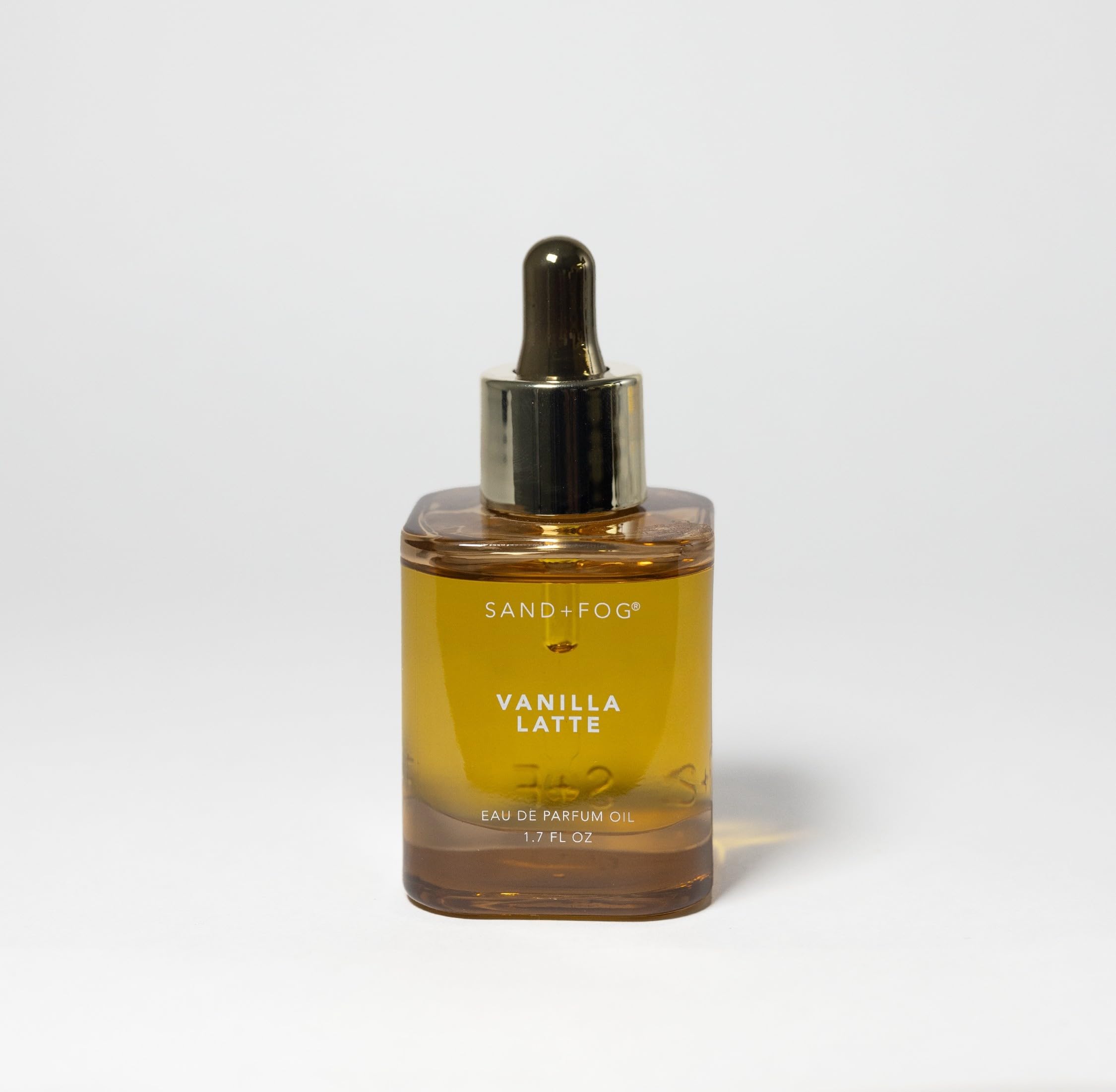 Close-up of Sand + Fog Vanilla Latte parfum oil bottle with amber glass for cozy notes.