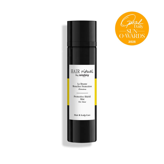 Damp hair being misted with Sisley Hair Rituel Protective Shield Mist for smoother strands.