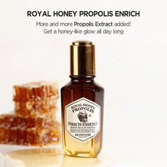 SKINFOOD 1957 Royal Honey Propolis Enrich Essence glass bottle scene with warm lighting.