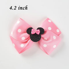Snokkcomss clip mechanism shown securing hair with bow.