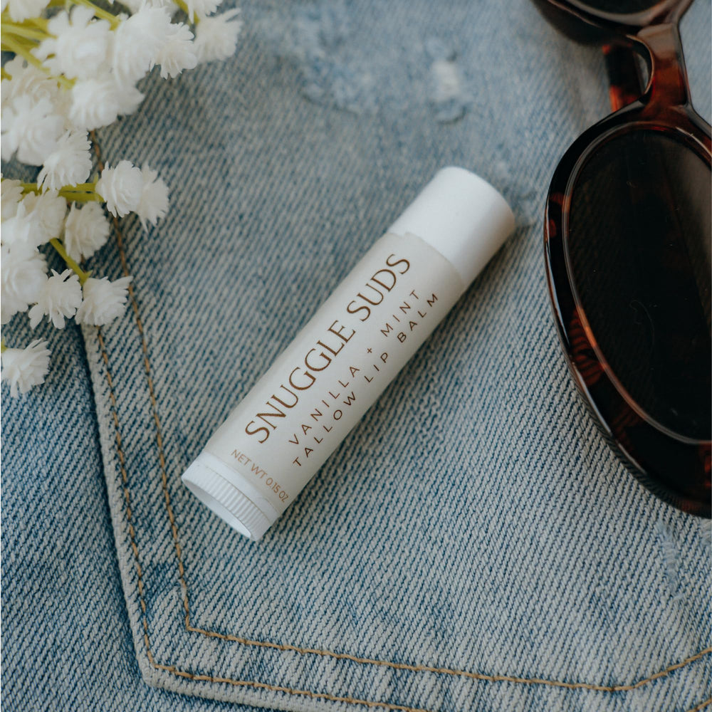 Snuggle Suds lip balm application close-up for smooth, non-greasy hydration.