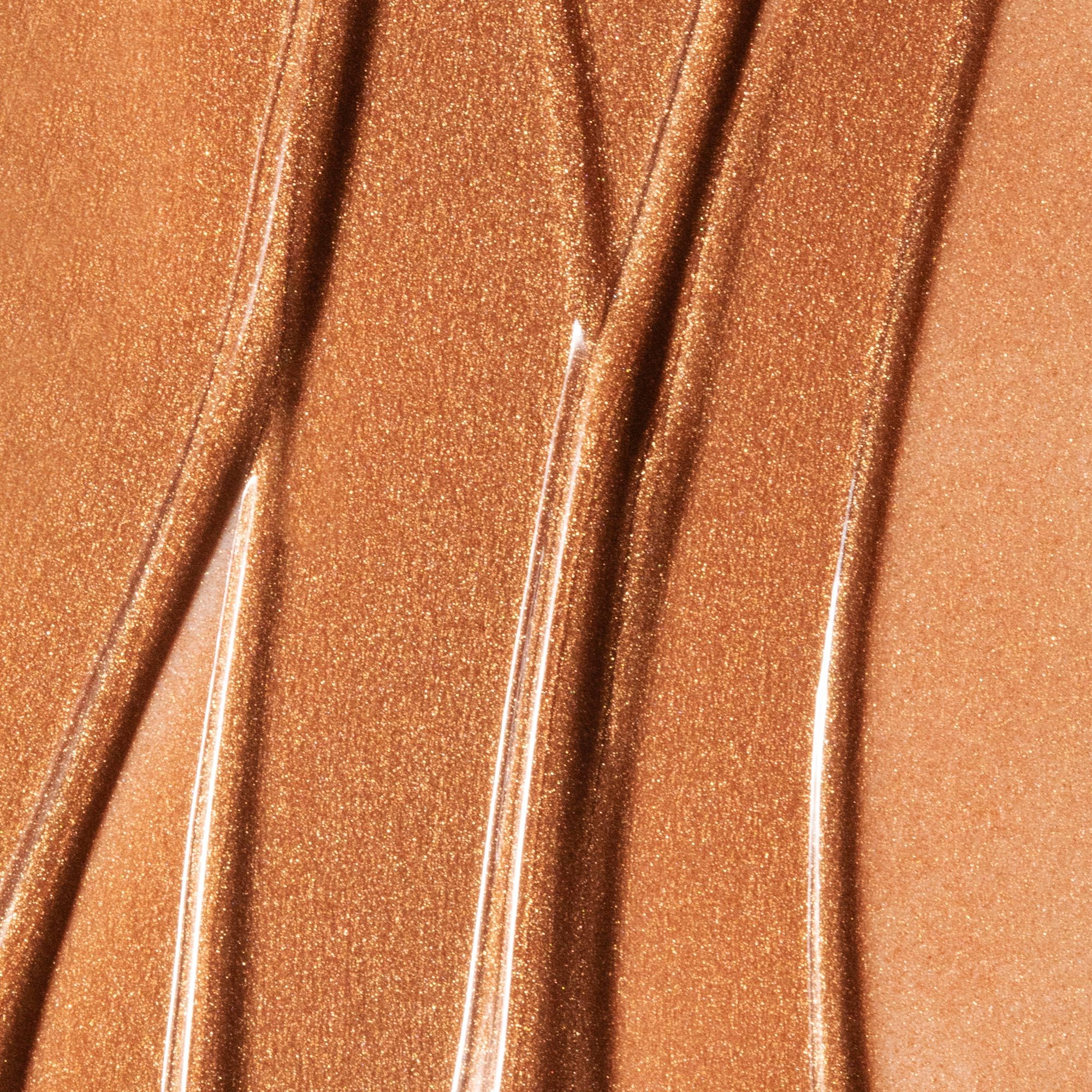 Summer Fridays Bronzing Drops on cheek creating a soft glow.