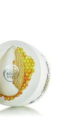 Hands applying The Body Shop Almond Milk & Honey butter for dry skin relief