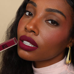 The Lip Bar Juicy Pout Lip Care Duo on lips for smooth prep.