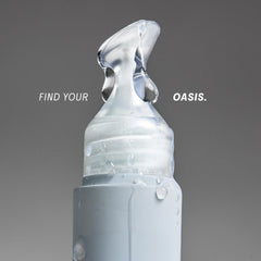 The Outset Lip Oasis clear gloss bottle shows a sleek, glassy finish for everyday wear.