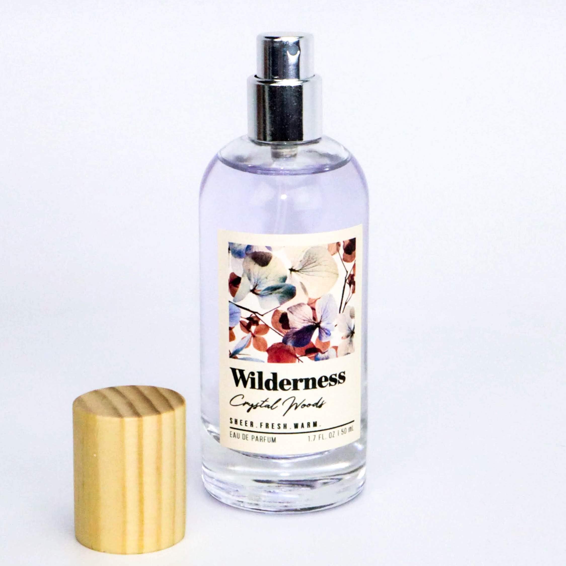 Tru Fragrance Beauty Wilderness Crystal Woods EDP bottle on wood surface evoking nature-inspired scent
