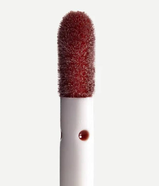 Typology lip oil swatch on lips showing a glossy, non-sticky finish