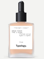 Typology tinted serum bottle dispensing for light, radiant coverage and hydration.