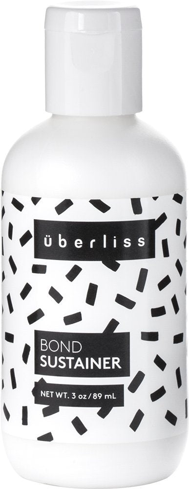 Uberliss Bond Repair Conditioner bottle pouring for instant hydration and bond restoration.