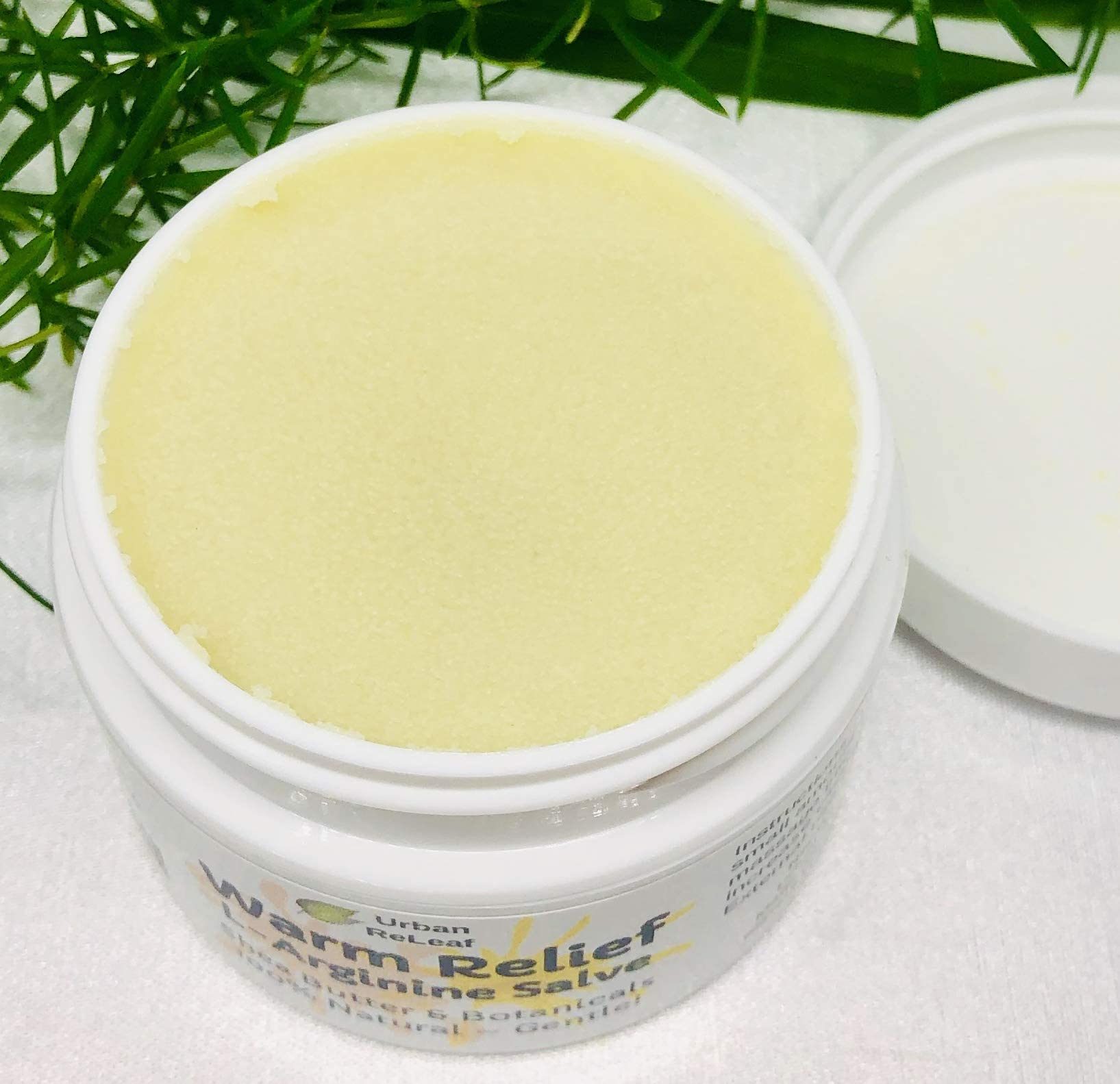 Urban ReLeaf Warm Relief Salve jar close-up showing shea butter and botanicals.