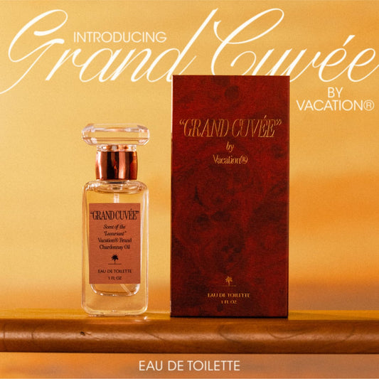 VACATION Grand Cuve9e on a sunlit beach scene, travel-friendly fragrance in focus.