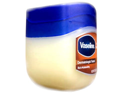 Hands applying Vaseline to dry skin for a soft, healthy-looking glow.
