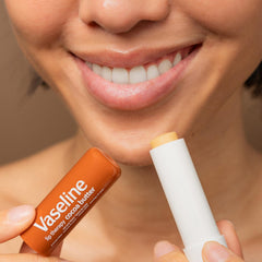 Vaseline Lip Therapy tube with cap removed revealing balm inside.