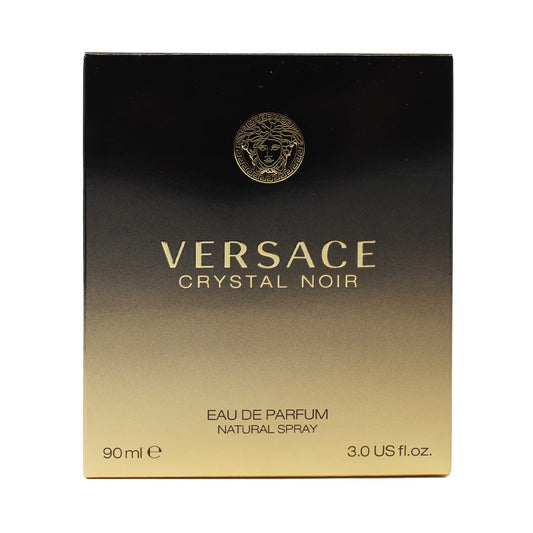 Versace Crystal Noir bottle on a reflective surface, ideal for evening wear.